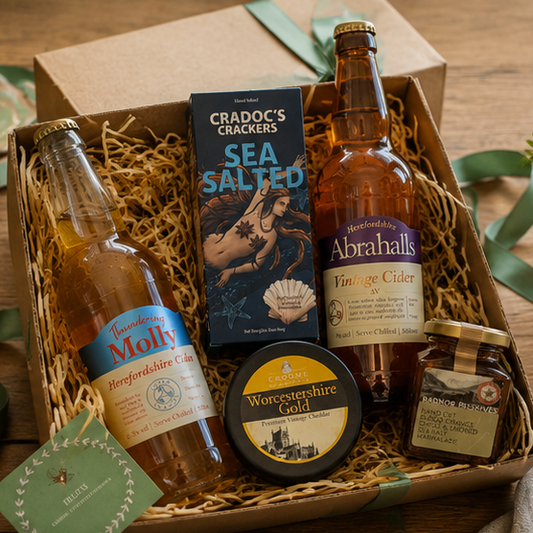 Gift basket with Abrahalls cider, Molly cider, and other items on a wooden surface.