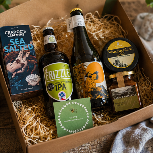 Gift box with beer bottles, crackers, and other items on a wooden surface