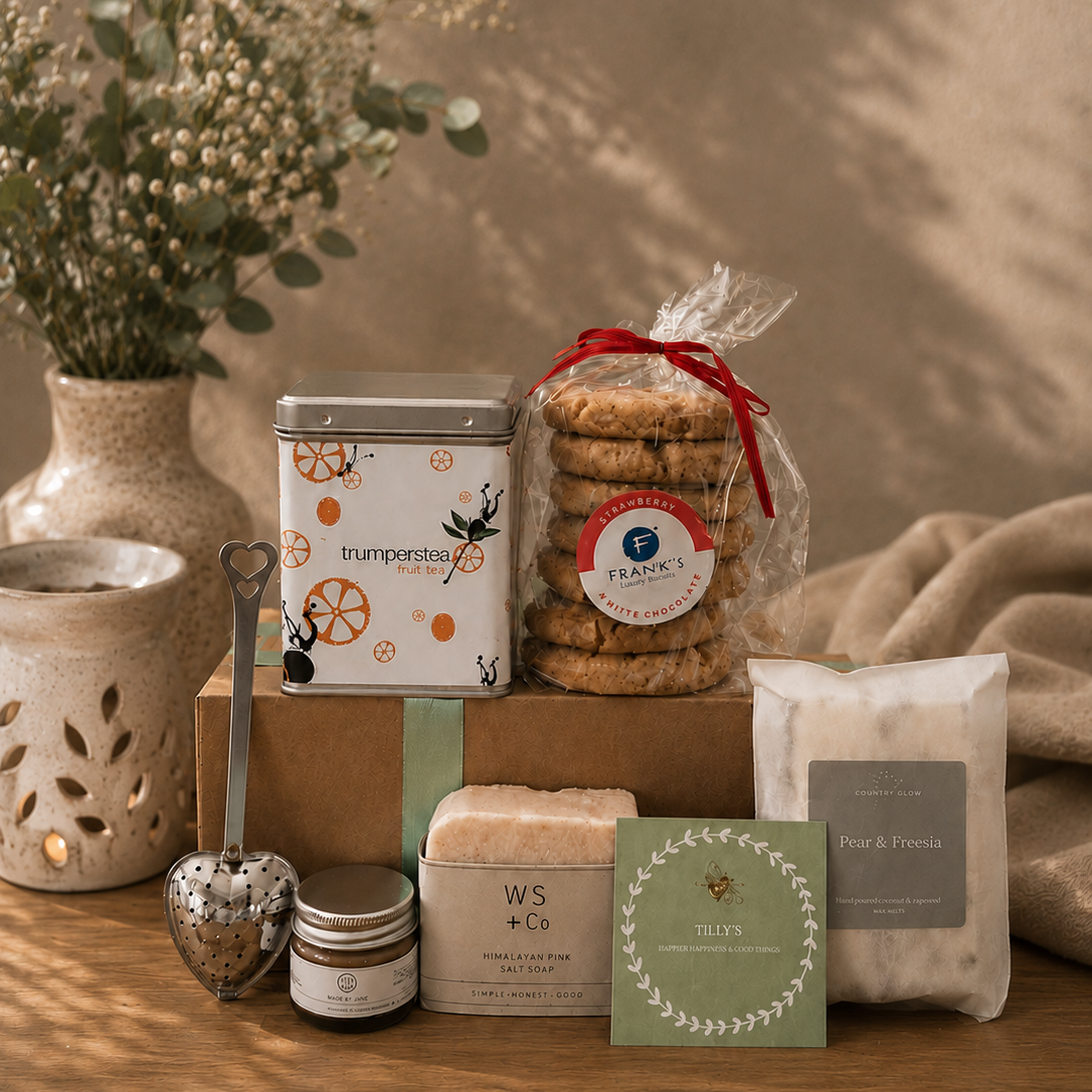 Assorted products including cookies, candles, and a tea canister on a wooden surface with a warm ambiance.