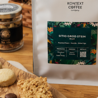 Kontext Coffee package with a label on a wooden surface with snacks.